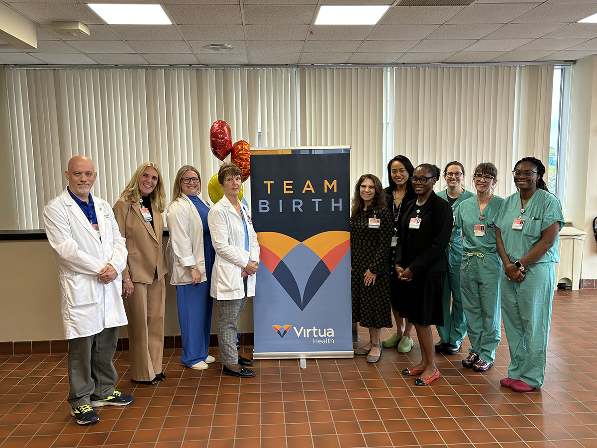 Group of medical professionals with sign reading TeamBirth - Virtua