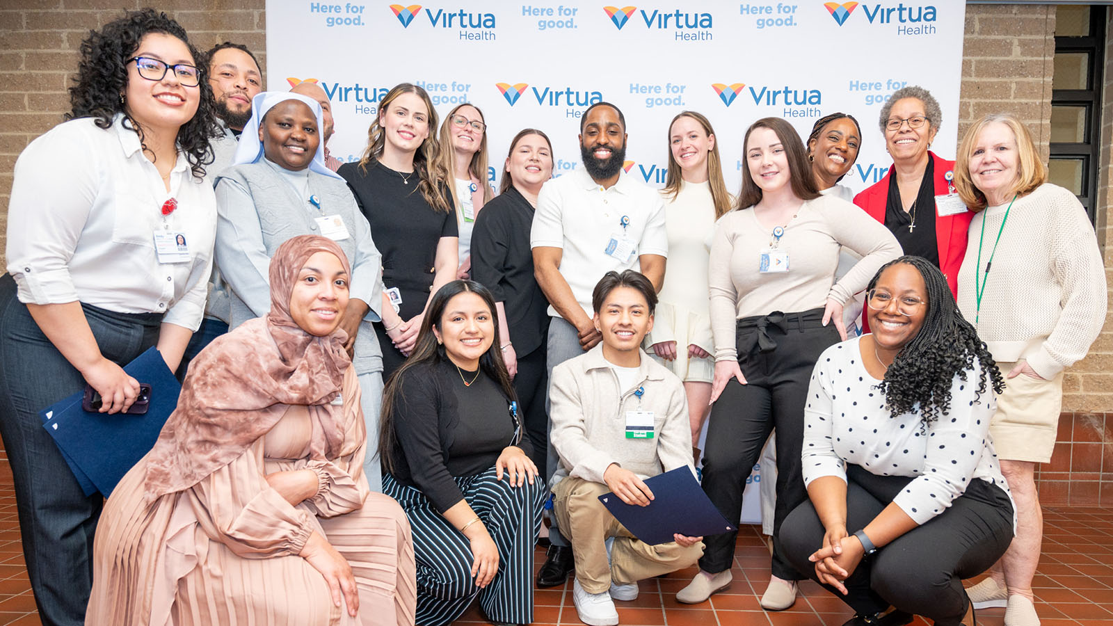 Group of nursing students and administration smiling in front of a Virtua Health sign
