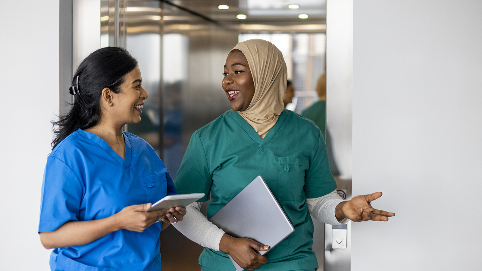 Two female healthcare workers of different nationalities talking together