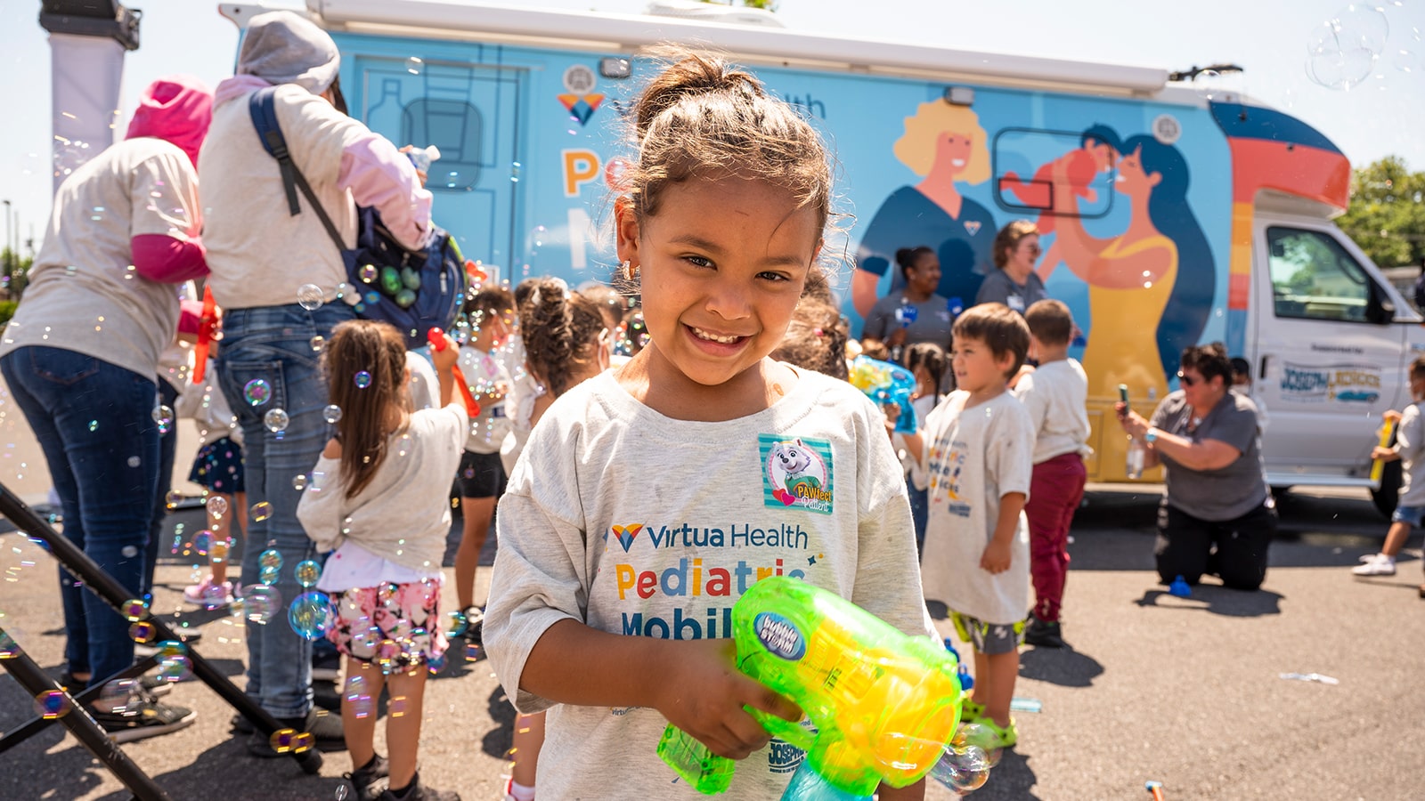 A young girl is outside playing with a water squirter