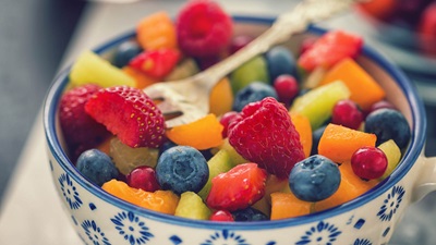 bowl of fruit salad with a fork on top