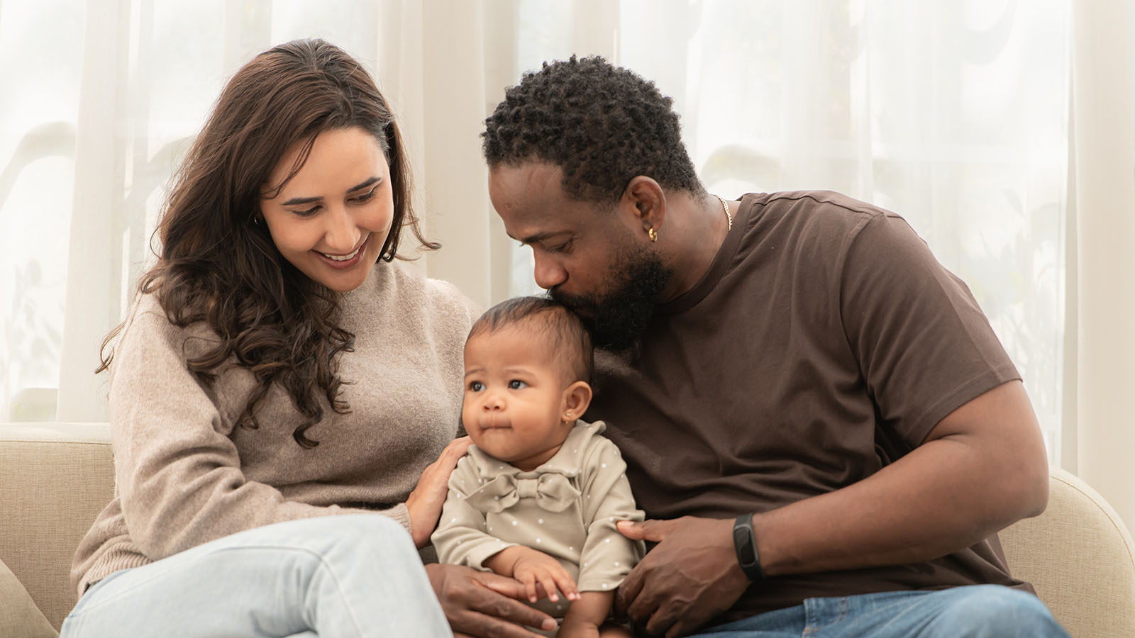 mom, dad, and baby sitting on a couch