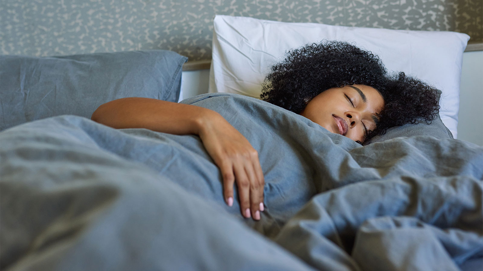 Young woman peacefully sleeping with a weighted blanket