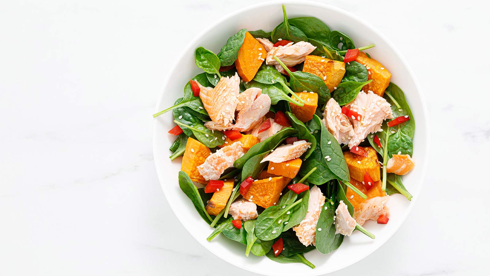 bowl of salad with salmon and sweet potatoes