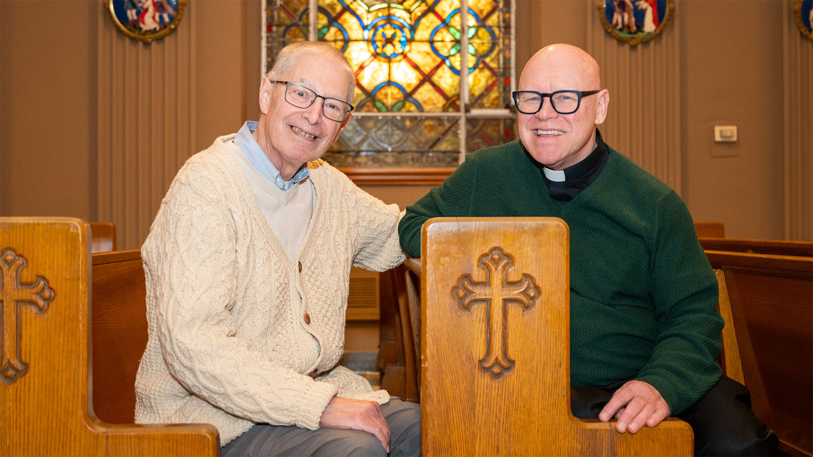 75-year-old male patient sits in a chapel with a priest, smiling and talking, at Virtua Our Lady of Lourdes Hospital