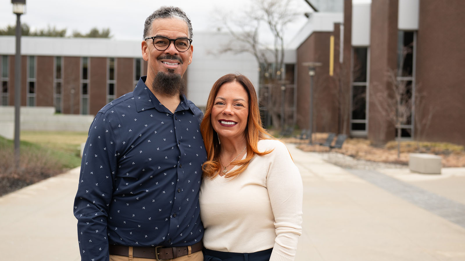 Image of Virtua Patient Michael, and his wife, smiling and standing in front of a building