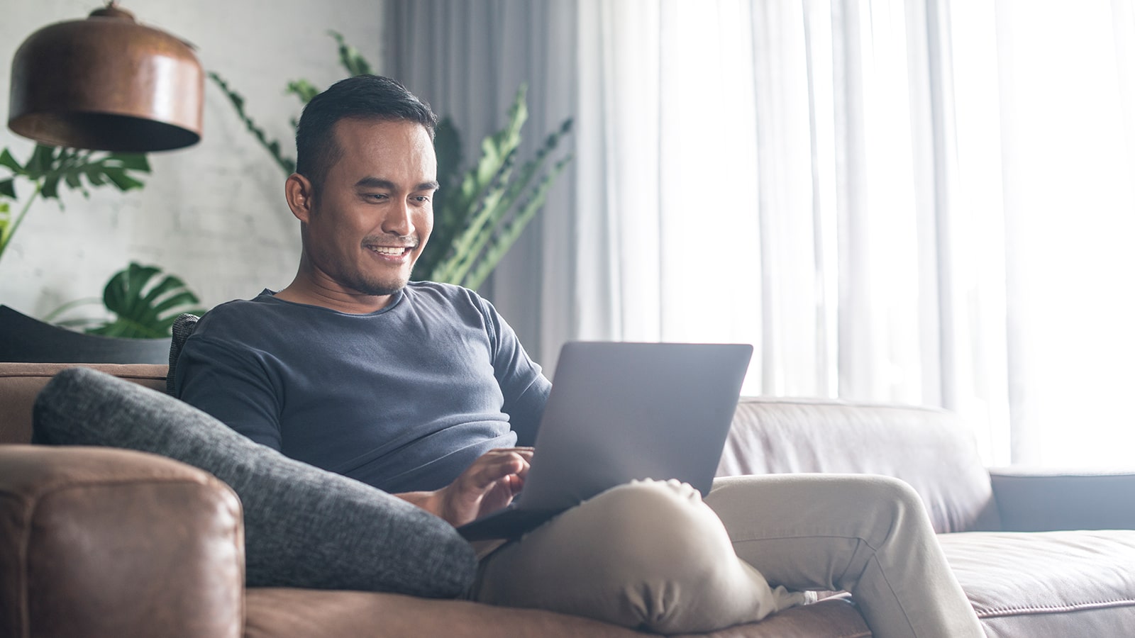 Man sitting on a couch with a laptop