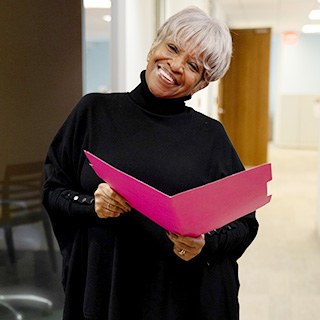 Antoinette Llyod smiling holding an folder